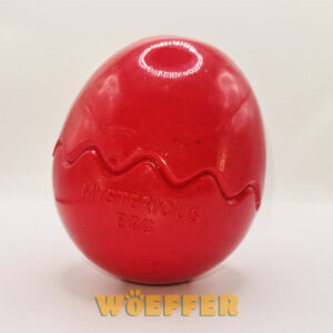 Rood eivormig speeltje. Daaronder het logo van Woeffer.